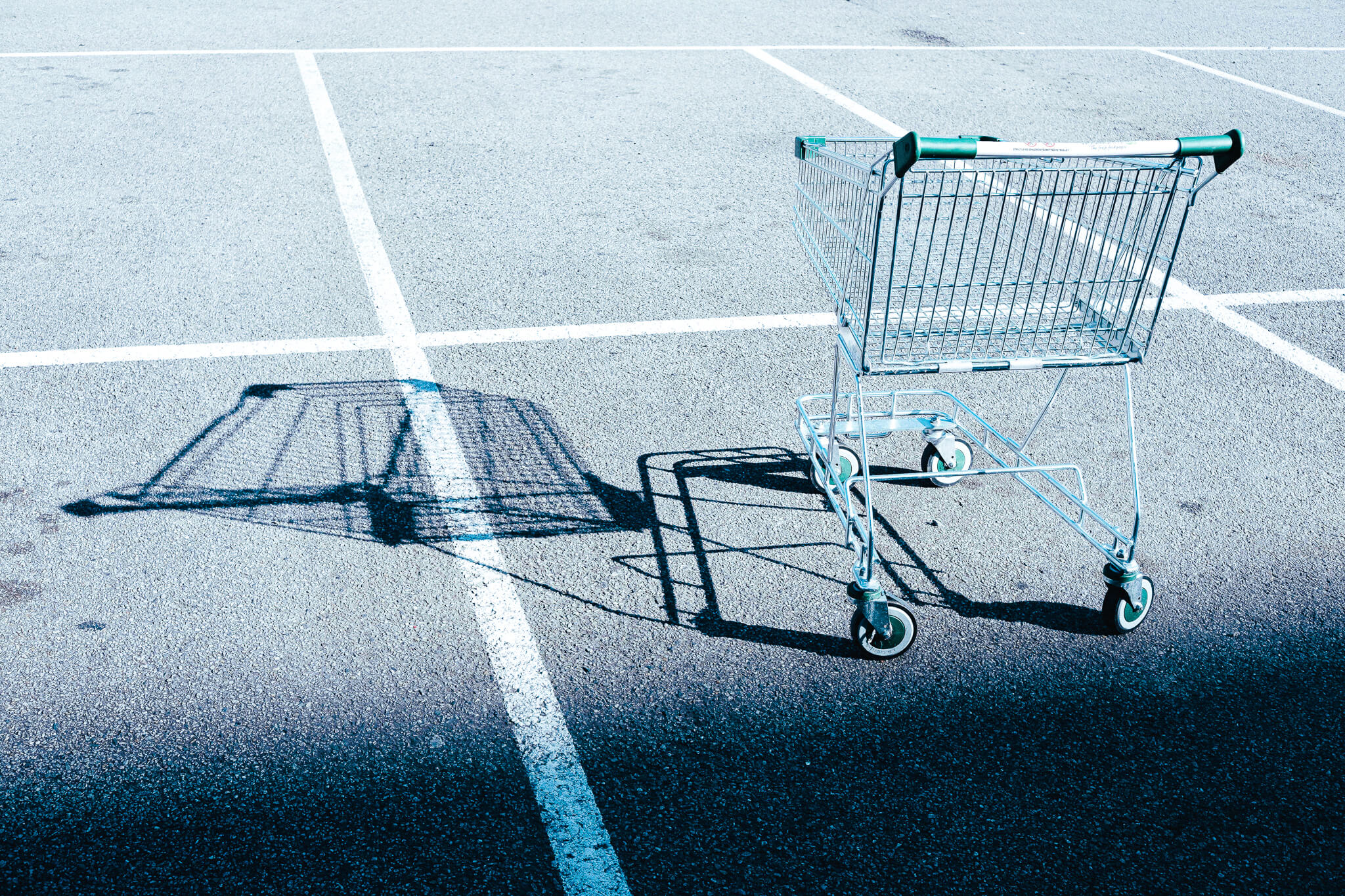 Ein Einkaufswagen steht verlassen auf einem Parkplatz