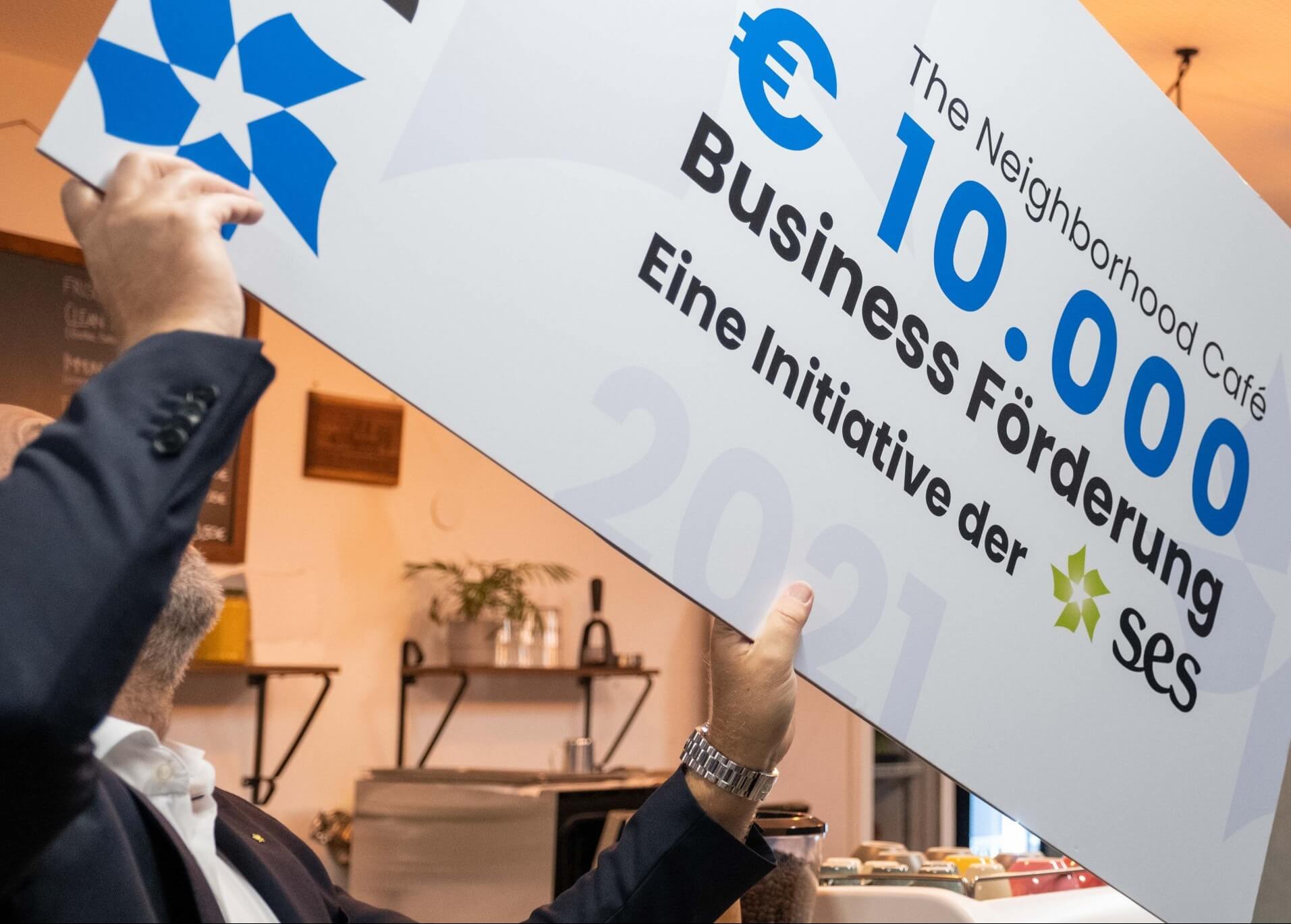 Mann der eine yip.at Business-Förderungs-Urkunde in die Luft hält