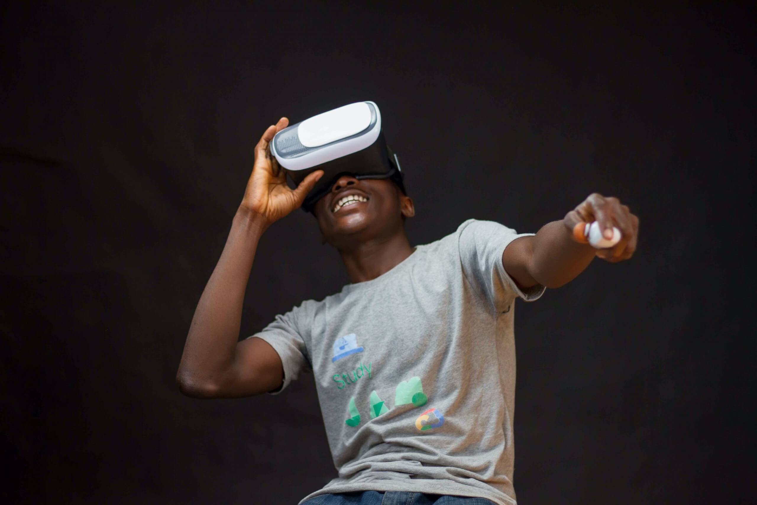 Ein lachender Mann in einem grauen Shirt und einer VR-Brille